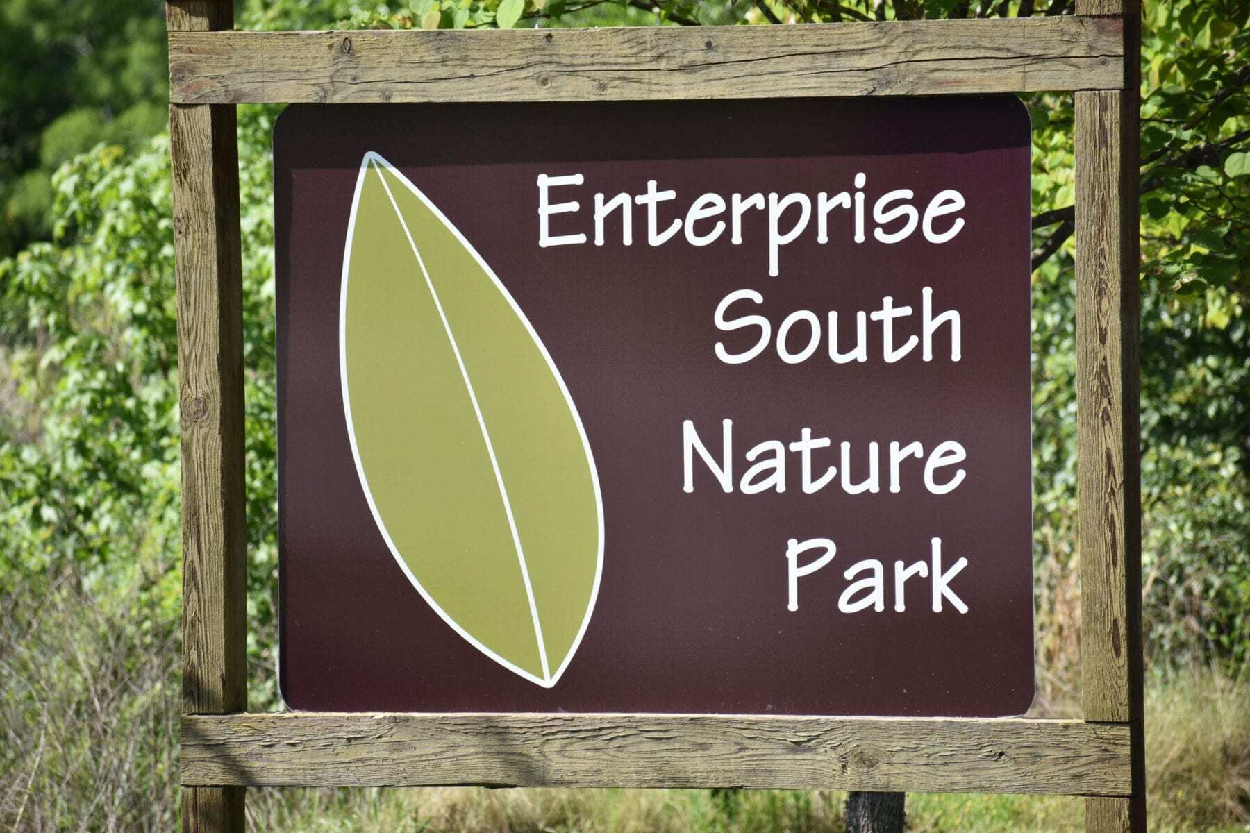 "Brown sign with white lettering reading 'Enterprise South Nature Park' with a single leaf on it, located in Chattanooga TN."