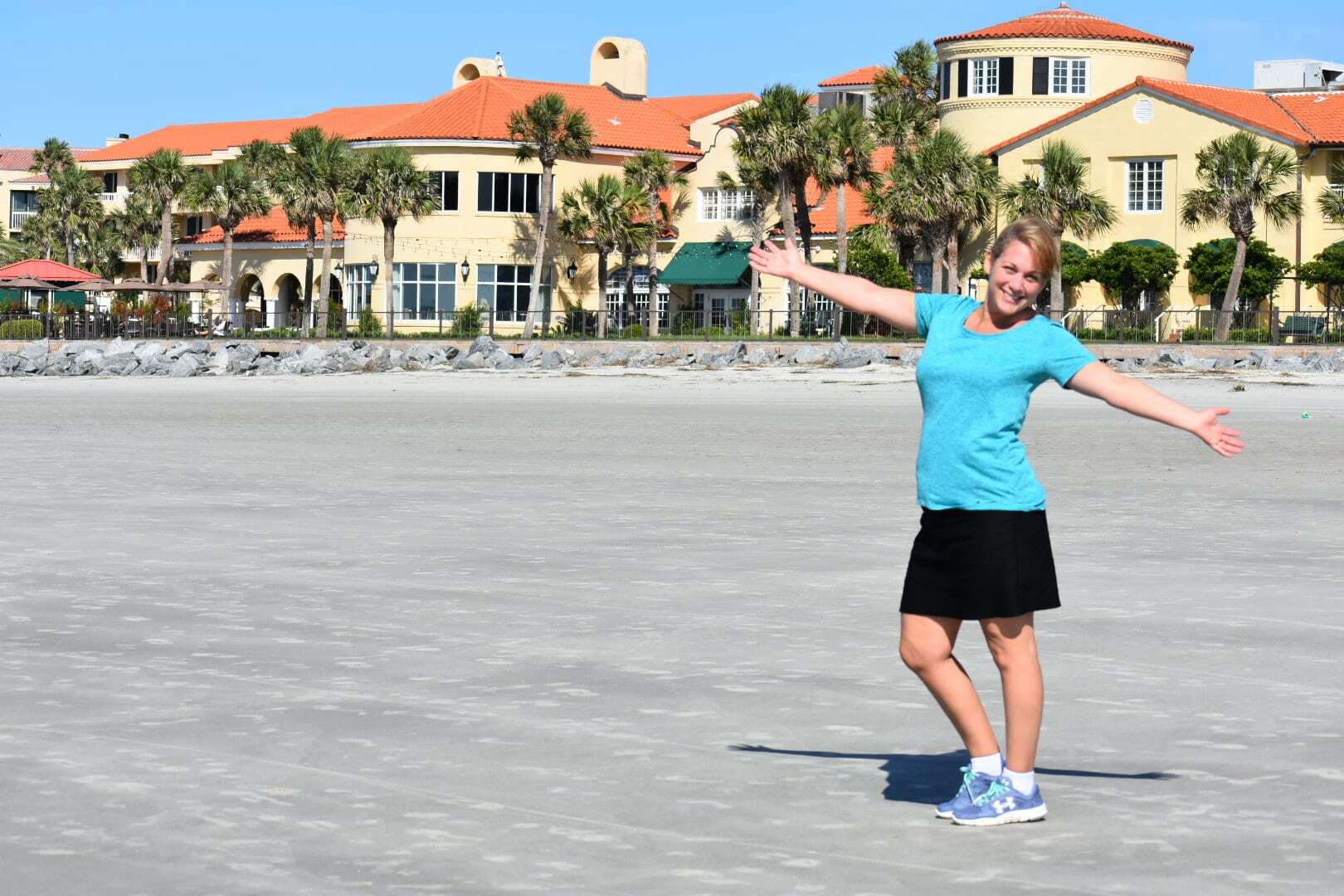 Travel Blogger Kathy Brown on the beautiful beaches of Saint Simon Island, Georgia. Standing infront of the massive resort complex of the historic King & Prince