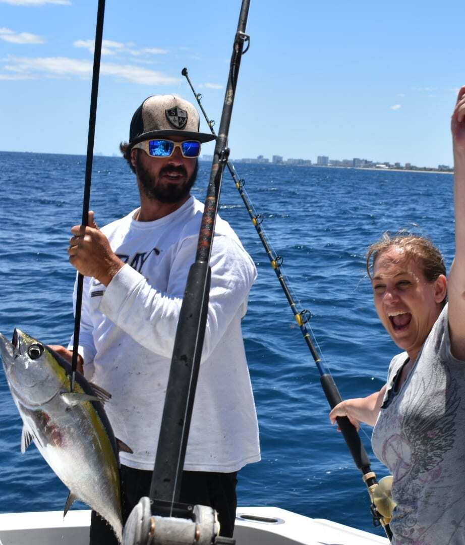 "Kathy Brown beaming with excitement as she proudly reels in a big Tuna fish, showcasing her hard work and effort"