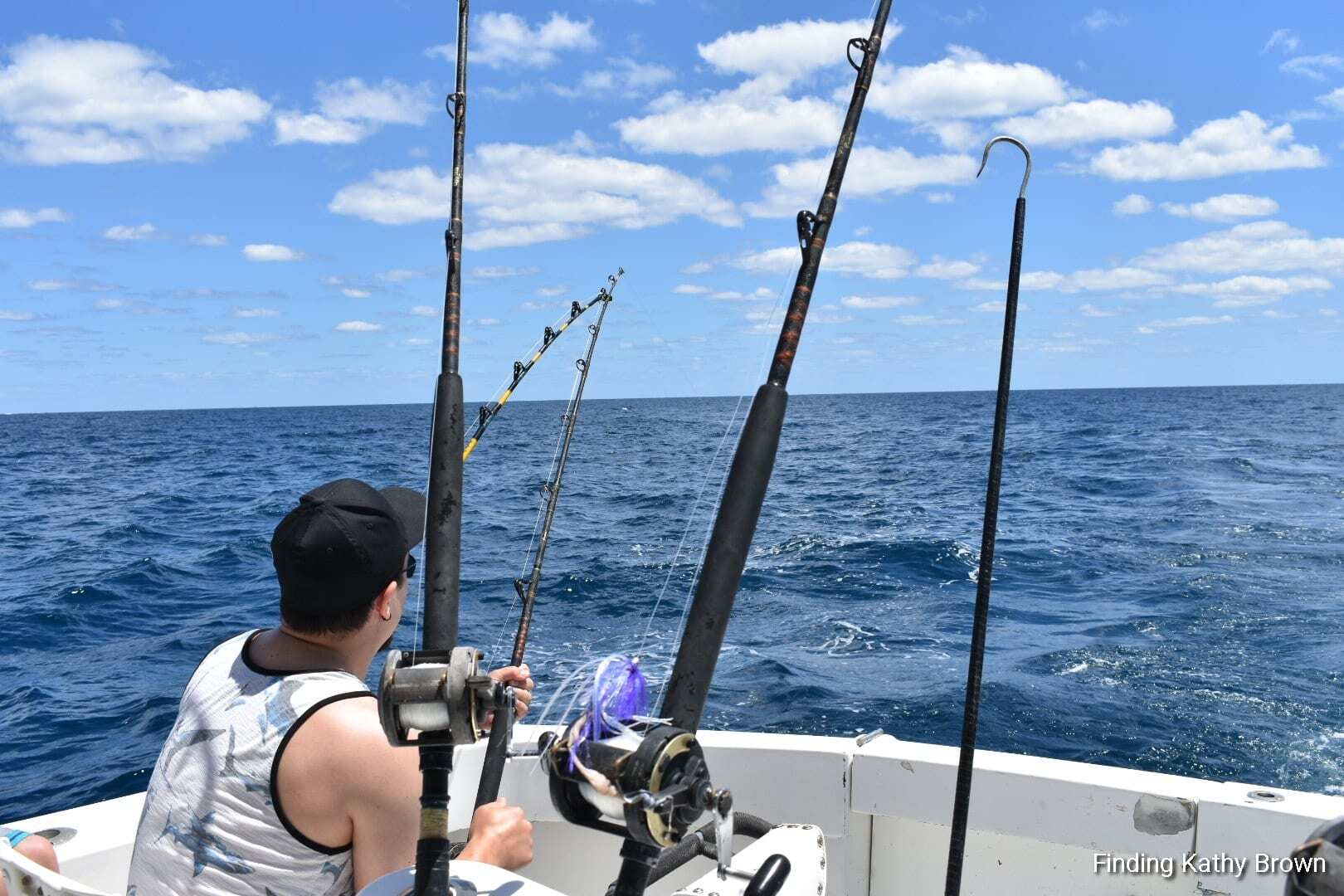 "Michael Denton excitedly reels in a big catch off the back of the BOLO charter fishing boat on a sunny day in South Florida"