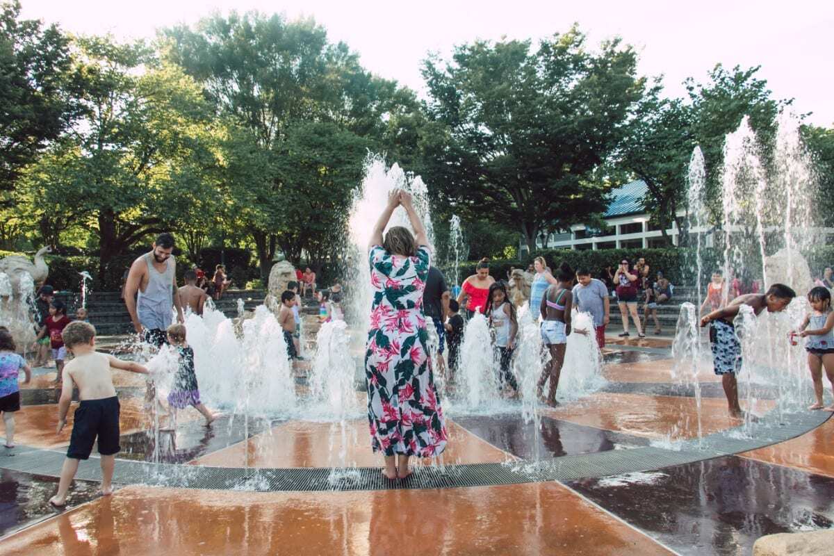 Woman and children playing in a splash pad fountain Finding Kathy Brown 99 things to do in Chattanooga, TN Image Jordon Anne Photo