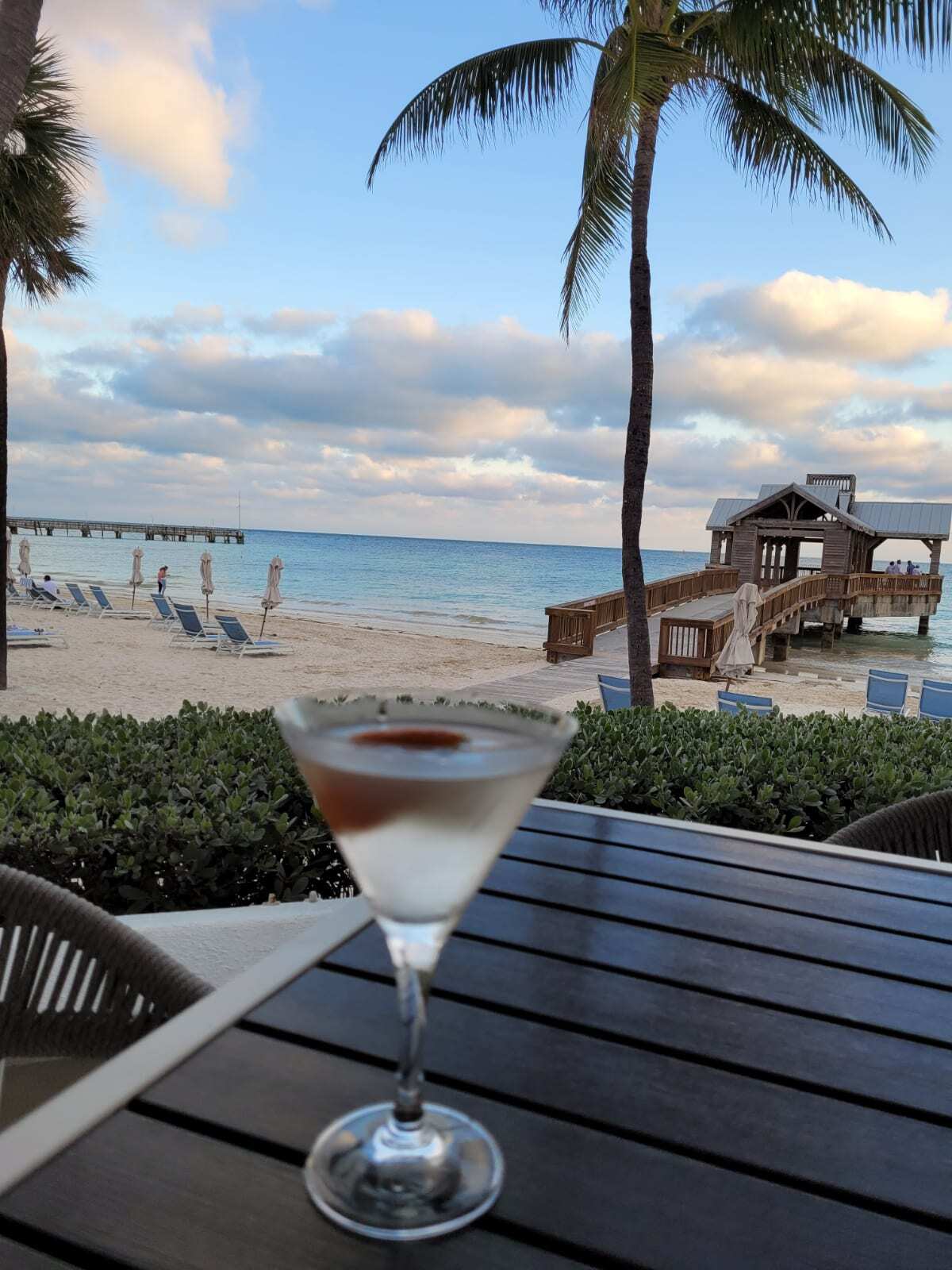Martini with a cherry garnish overlooking the blue ocean and pier located at The Reach Resort Key West Florida