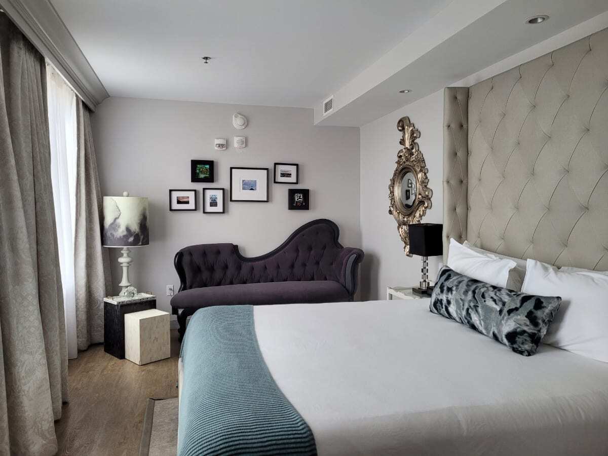 Chic bedroom, luxury bedding, chase lounge and art in room accommodations of Edwin