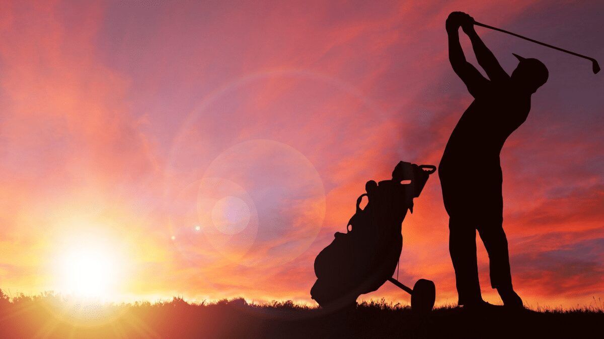 Man golfing at sunset