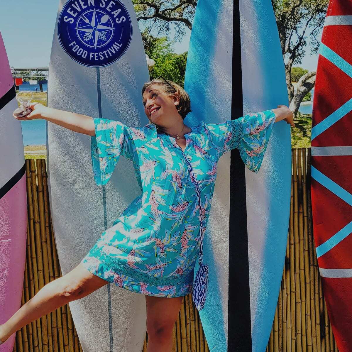USA woman travel blogger dancing at a Seven Seas Food Festival sign