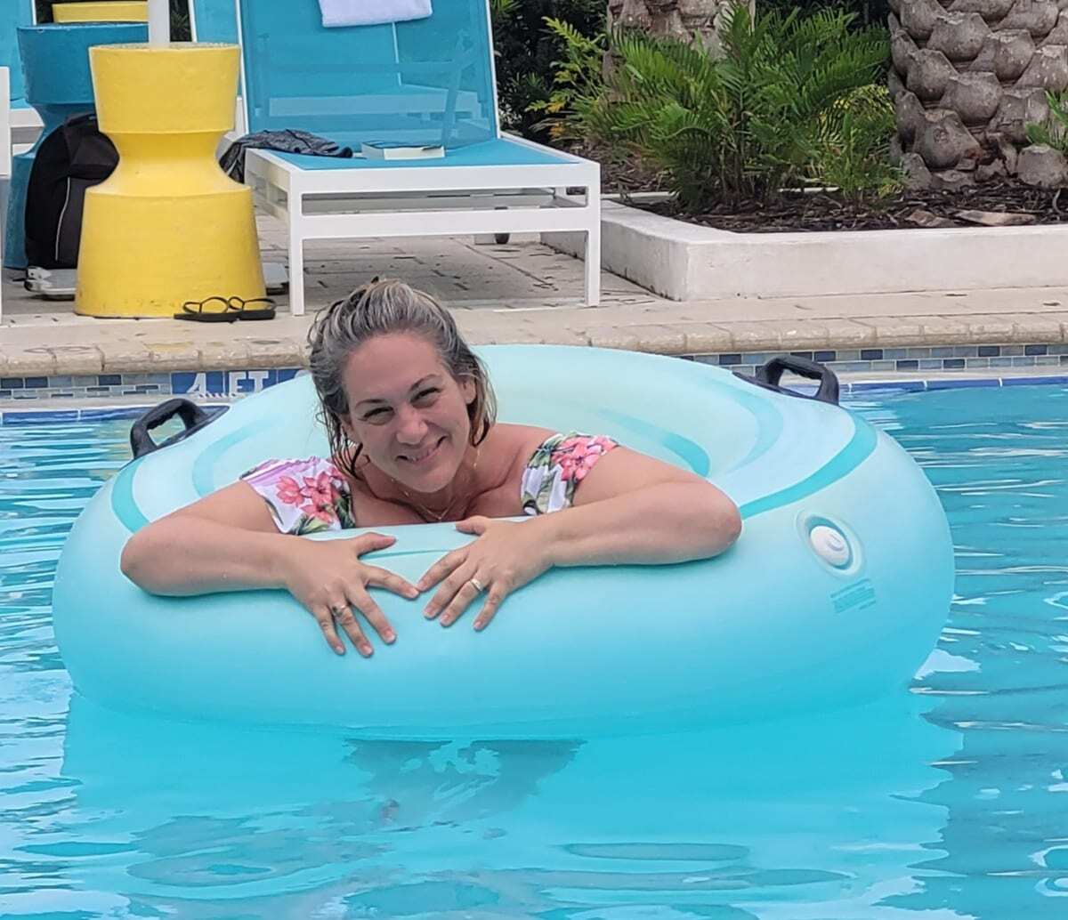 Woman smiling in a bathing suite while floating in a pool. Image: Finding Kathy Brown USA Travel Blogger at The Hilton Buena Vista Palace Resort Orlando, FL USA