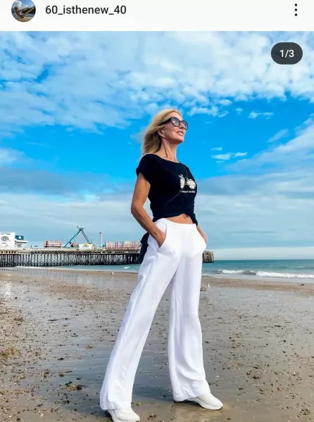 50 plus women Leigh, the cool influencer, confidently proving that 60 is the new 40! Her slender figure and long blonde hair radiate vitality. In the image, she's wearing a Stylish Outfit on the beach. showcasing her commitment to a balanced, active lifestyle that defies age stereotypes.