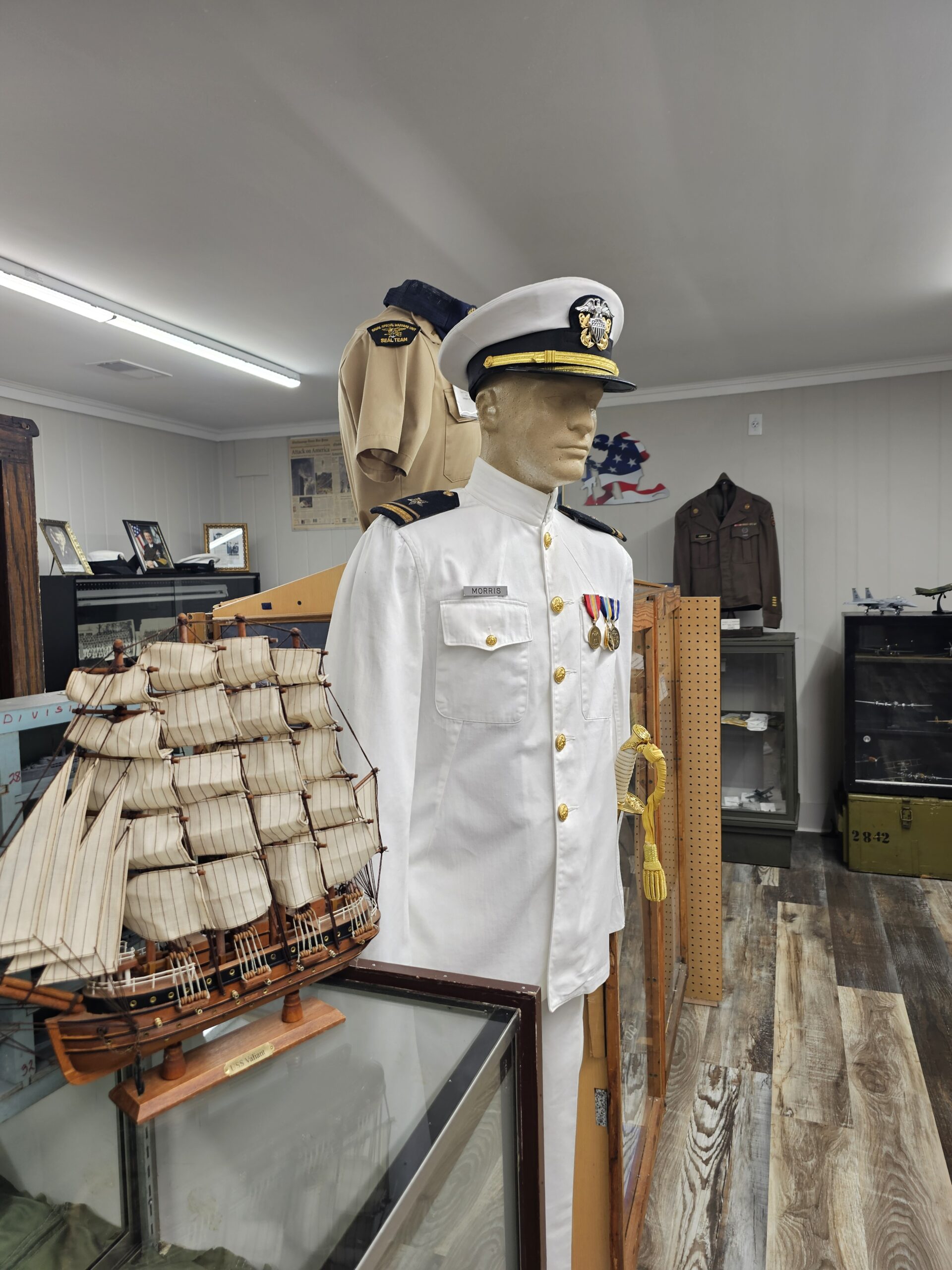 Close-up of a military uniform displayed at the Dade County Georgia Military Museum. The uniform includes a neatly pressed jacket with insignia, badges, and medals, showcasing the rank and service branch. The details highlight historical military apparel, preserving the legacy of service members.